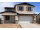 Two-story home featuring a neutral stucco exterior, two-car garage, and decorative shutters at 22368 W Monona Ln, Surprise, AZ 85387