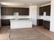 Spacious kitchen featuring dark wood cabinets, a center island, white countertops, and stainless steel appliances at 22368 W Monona Ln, Surprise, AZ 85387