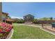 Beautiful backyard featuring lush green grass, bushes, and a charming paved area with a stone bench at 2257 E Redwood Ct, Chandler, AZ 85286