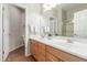 Well-lit bathroom with double sinks, wooden cabinetry, and a tiled floor at 2257 E Redwood Ct, Chandler, AZ 85286