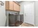 Modern laundry room with upper cabinets and sleek washer and dryer at 2257 E Redwood Ct, Chandler, AZ 85286