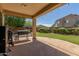 Covered patio featuring an outdoor kitchen, string lights, and views of the landscaped backyard at 2257 E Redwood Ct, Chandler, AZ 85286