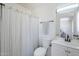 Clean bathroom with white vanity, toilet, and shower with striped curtain at 2338 E Folley St, Chandler, AZ 85225