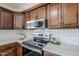 Bright kitchen featuring stainless steel appliances, dark wood cabinets, and quartz countertops at 2338 E Folley St, Chandler, AZ 85225
