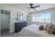 Bright main bedroom features a ceiling fan, a large window, and gray dresser with decor at 2338 E Folley St, Chandler, AZ 85225