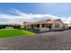 Backyard featuring outdoor kitchen, covered patio, green lawn, and gravel area at 25875 S 227Th Way, Queen Creek, AZ 85142