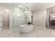 Bright bathroom features a chandelier, white bathtub, and glass enclosed shower at 25875 S 227Th Way, Queen Creek, AZ 85142
