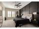 Modern bedroom featuring a dark accent wall, a ceiling fan, and a window with shutters at 25875 S 227Th Way, Queen Creek, AZ 85142