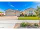 Charming single-story home featuring a three-car garage, well-manicured lawn, and desert landscaping for curb appeal at 25875 S 227Th Way, Queen Creek, AZ 85142