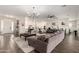 Spacious living room with hardwood floors, modern lighting, and a seamless flow into the kitchen and dining area at 25875 S 227Th Way, Queen Creek, AZ 85142