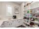 Well-organized pantry with white cabinetry and shelving for ample storage space and natural light at 25875 S 227Th Way, Queen Creek, AZ 85142