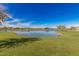 Scenic pond surrounded by lush green grass and community buildings, creating a serene and picturesque setting at 25875 S 227Th Way, Queen Creek, AZ 85142