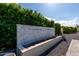 Outdoor water feature with tiled wall, set against lush green hedges and blue skies, adds elegance to the property at 25875 S 227Th Way, Queen Creek, AZ 85142