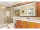 Bathroom with a walk-in shower, wood vanity, and large framed mirror at 2745 S Emerson Cir, Mesa, AZ 85210