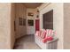 Cozy covered porch with a comfortable cushioned bench, perfect for enjoying the outdoors and a red front door at 2926 N 149Th Dr, Goodyear, AZ 85395