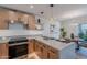 Kitchen featuring light wood cabinets, stainless steel appliances, an island with seating, and open shelving at 3033 N 39Th St # 5, Phoenix, AZ 85018