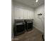 Modern laundry room with a gray front-load washer and dryer and white overhead cabinets at 333 W Bethany Home Rd, Phoenix, AZ 85013