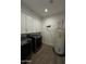 Well-equipped laundry room with modern washer and dryer, overhead storage, and clean, wood-look flooring at 333 W Bethany Home Rd, Phoenix, AZ 85013