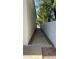 Narrow side yard with gravel, concrete walkway, and tall white walls at 333 W Bethany Home Rd, Phoenix, AZ 85013
