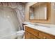 Cozy bathroom with a shower-tub combo, decorative mirror, and neutral color palette at 4112 W Monte Cristo Ave, Phoenix, AZ 85053
