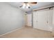 Simple bedroom featuring a closet, neutral carpeting, and a ceiling fan at 4112 W Monte Cristo Ave, Phoenix, AZ 85053