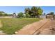 Wide shot of open grassy grounds with various outbuildings and mature trees at 4112 W Monte Cristo Ave, Phoenix, AZ 85053