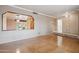 Empty living room with hardwood floors, neutral walls, and an open concept that connects seamlessly to the dining area at 4112 W Monte Cristo Ave, Phoenix, AZ 85053