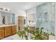 Bright bathroom featuring a blue-tiled walk-in shower, wood vanity, and stylish plants for décor at 4204 S Winter Ln, Gilbert, AZ 85297