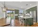 Bright kitchen with green cabinets, stainless steel appliances, island with marble countertop, and access to the backyard at 4204 S Winter Ln, Gilbert, AZ 85297