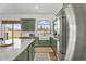 A bright kitchen with stainless steel appliances, green cabinets, white subway tile backsplash, terracotta tile floor at 4204 S Winter Ln, Gilbert, AZ 85297