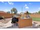 Backyard with outdoor kitchen featuring a sink, BBQ grill, and a playground at 4204 S Winter Ln, Gilbert, AZ 85297