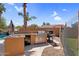 Outdoor kitchen featuring a BBQ grill, sink and waterfall pool in a well landscaped setting at 4204 S Winter Ln, Gilbert, AZ 85297