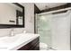 Contemporary bathroom with a dark vanity, framed mirror, and a glass-enclosed shower with modern tiling at 4600 N 68Th St # 302, Scottsdale, AZ 85251