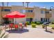 Inviting community area with BBQ, seating under red umbrellas, and lush green landscaping at 4600 N 68Th St # 302, Scottsdale, AZ 85251