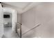 Bright hallway with modern railings leads to a bedroom with a desk and television at 4600 N 68Th St # 302, Scottsdale, AZ 85251