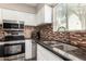 Well-equipped kitchen featuring stainless steel appliances, dark countertops, and a decorative backsplash at 4600 N 68Th St # 302, Scottsdale, AZ 85251