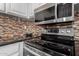 Kitchen with stainless steel oven and microwave, granite countertop, and decorative tile backsplash at 4600 N 68Th St # 302, Scottsdale, AZ 85251
