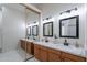 Bathroom showcasing double sinks, wooden cabinets, and a large mirror at 480 S Seawynds Blvd, Gilbert, AZ 85233