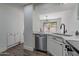 Kitchen sink with stainless steel dishwasher, white cabinets, and stone countertops at 480 S Seawynds Blvd, Gilbert, AZ 85233