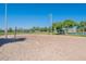 Sandy volleyball court with net, poles, and surrounding green trees and landscaping at 480 S Seawynds Blvd, Gilbert, AZ 85233