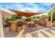 Outdoor patio with a bar, shade sail, dining area, and outdoor cooking facilities at 4822 E Charleston Ave, Scottsdale, AZ 85254