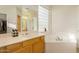 Bright bathroom featuring a soaking tub, spacious vanity, and a large window at 4822 E Charleston Ave, Scottsdale, AZ 85254