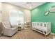 Bright Bedroom featuring a crib, glider and changing table, with accent wall and carpet at 4822 E Charleston Ave, Scottsdale, AZ 85254