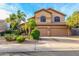 Two-story home featuring a three car garage, desert landscaping and mature palm trees at 4822 E Charleston Ave, Scottsdale, AZ 85254