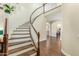 Elegant foyer features a curved staircase with hardwood floors and views to other rooms at 4822 E Charleston Ave, Scottsdale, AZ 85254
