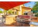 Outdoor kitchen area with built-in grill, bar and countertop space for entertaining guests at 4822 E Charleston Ave, Scottsdale, AZ 85254