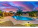 Inviting pool with waterfall feature, bar and desert landscaping under colorful sky at 4822 E Charleston Ave, Scottsdale, AZ 85254