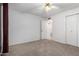 Bedroom with neutral carpet, ceiling fan, and an ensuite bathroom at 5055 E Enid Ave, Mesa, AZ 85206