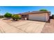 Single story home featuring an expansive driveway and an attached two car garage in a suburban neighborhood at 5055 E Enid Ave, Mesa, AZ 85206