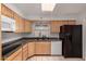 Galley kitchen featuring granite counters, wood cabinets, and a full appliance package at 5055 E Enid Ave, Mesa, AZ 85206